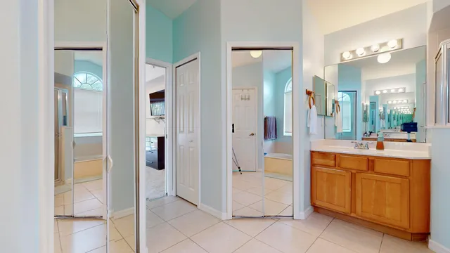 a large bathroom with a glass door shower a sink and a mirror