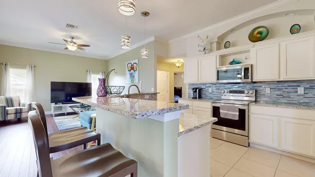 a kitchen with stainless steel appliances granite countertop a stove top oven a sink dishwasher a dining table and chairs with wooden floor