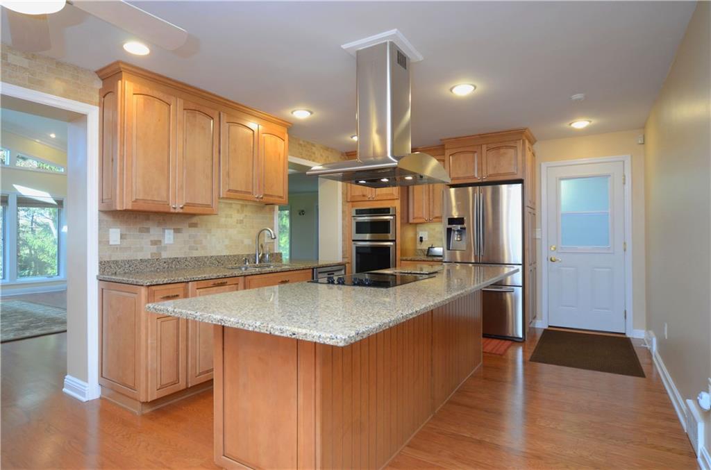 655 Bradys Ridge Road Beaver, PA 15009 - Photo 5 of 25 Spacious Kitchen includes custom cabinetry, granite countertops, electric cook top w/ sleek hood, convection oven/microwave combo, pull out pantry drawers, double layer utensil drawers and sound system control center. Tons of amenities!