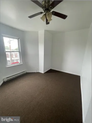an empty room with a ceiling fan and window
