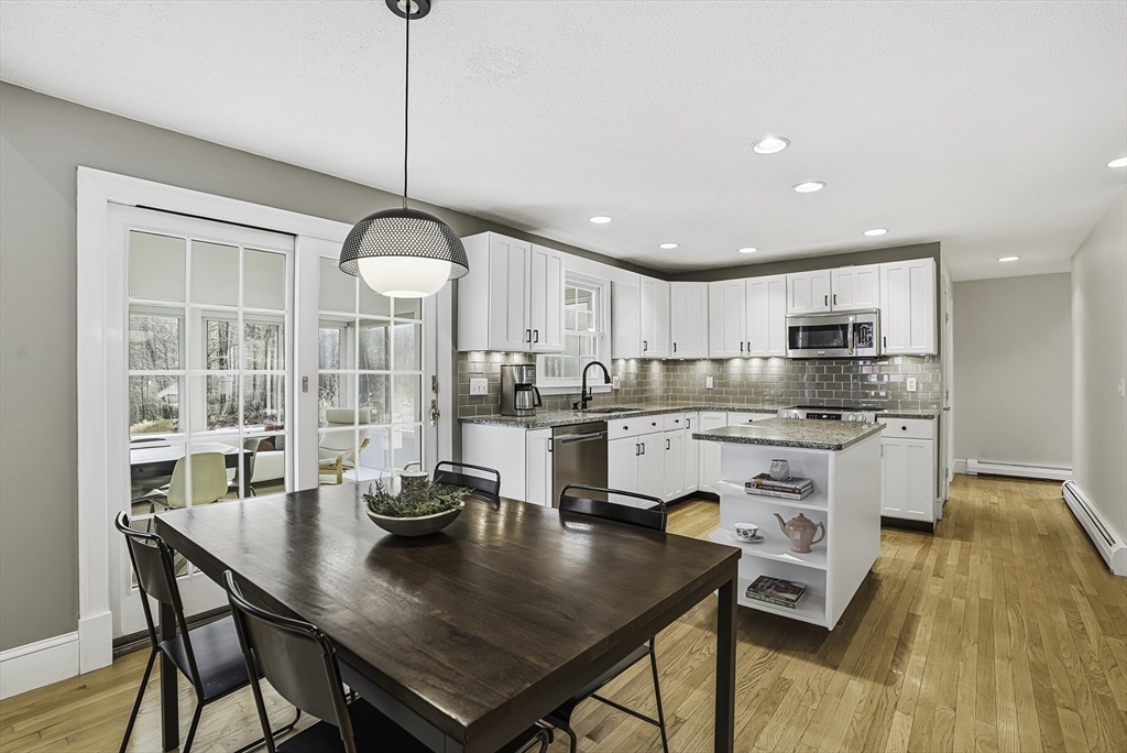 6 Hickory Lane Upton, MA 01568 - Photo 18 of 36 a kitchen with stainless steel appliances granite countertop a stove a refrigerator a kitchen island a table and chairs
