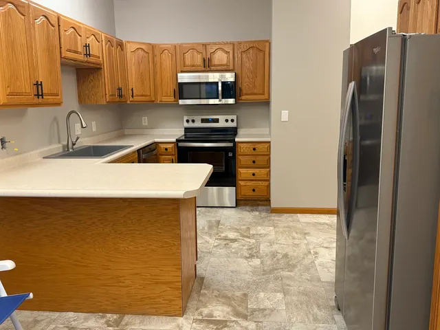 a kitchen with stainless steel appliances a refrigerator a stove a sink and a counter space