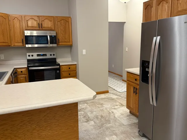 a kitchen with stainless steel appliances a refrigerator stove and microwave