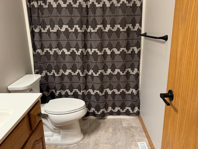 a bathroom with a toilet and a shower curtain