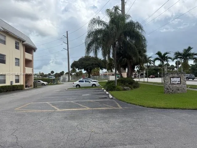 a view of a street with a cars parked and small park