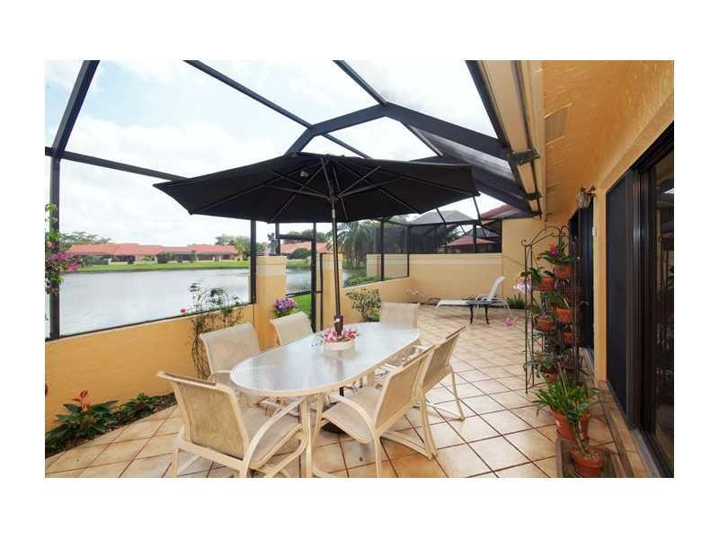 19972 Mona Circle, Unit 19972 Boca Raton, FL 33434 - Photo 18 of 22 a view of a patio with a table and chairs under an umbrella