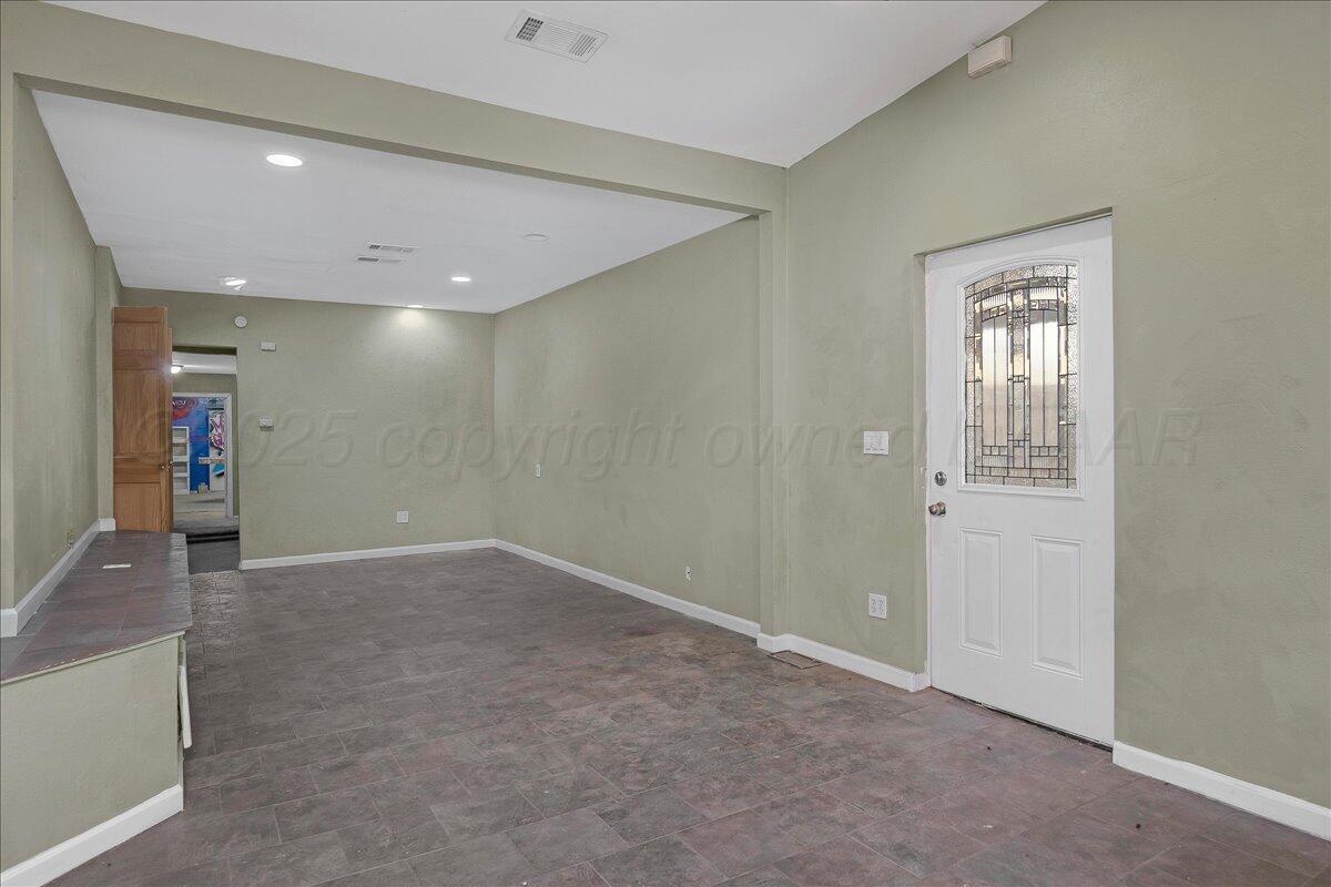 1403 South Hughes Street Amarillo, TX 79102 - Photo 11 of 54 an empty room with wooden floor and windows