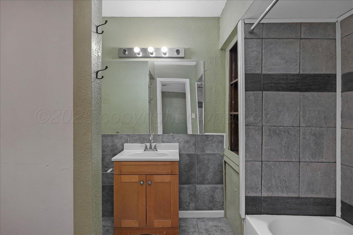 1403 South Hughes Street Amarillo, TX 79102 - Photo 25 of 54 a bathroom with a sink and a mirror