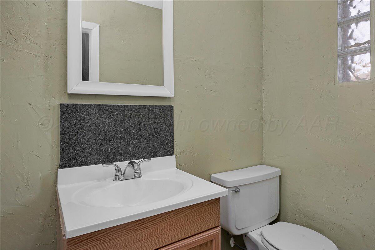 1403 South Hughes Street Amarillo, TX 79102 - Photo 27 of 54 a bathroom with a sink a toilet and mirror
