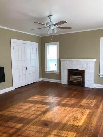 an empty room with windows and fireplace