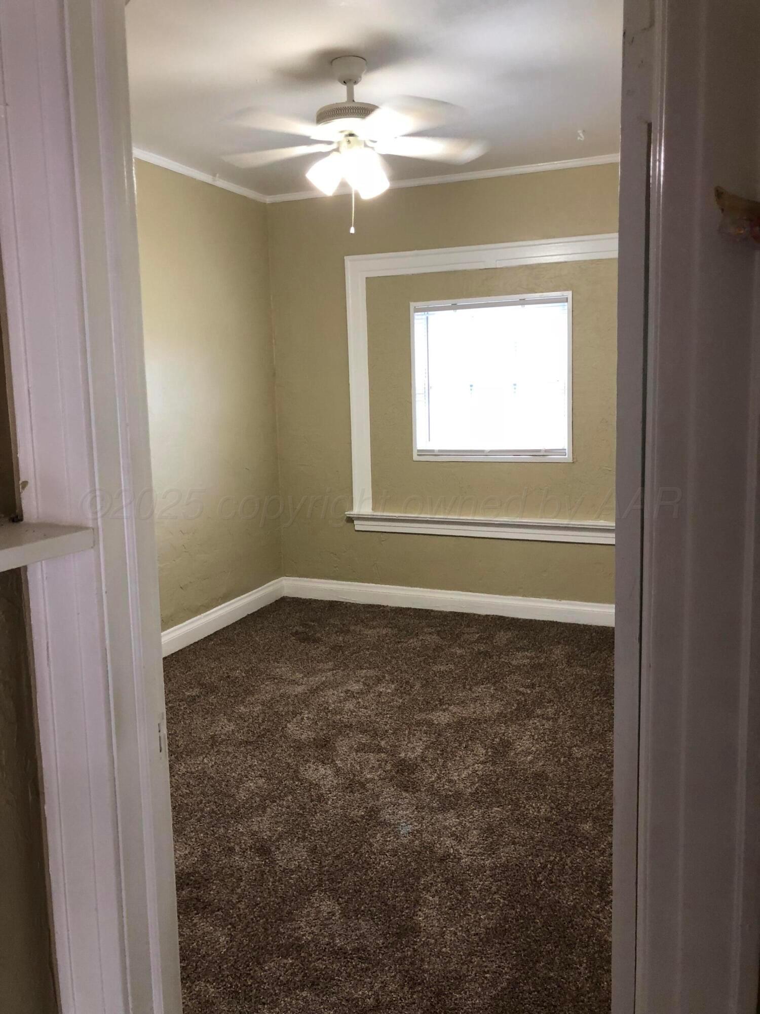 1403 South Hughes Street Amarillo, TX 79102 - Photo 39 of 54 a view of a livingroom with a ceiling fan and a window