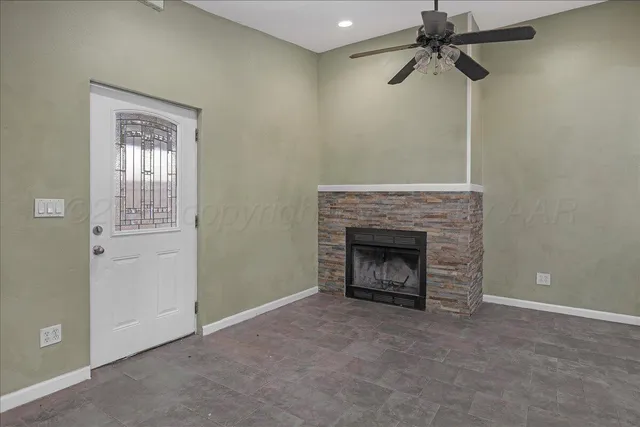 a view of an empty room with a fireplace and a window