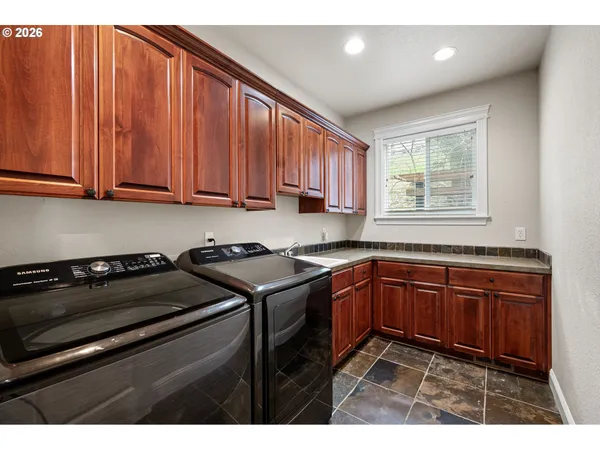 a kitchen with a sink a stove cabinets and wooden floor