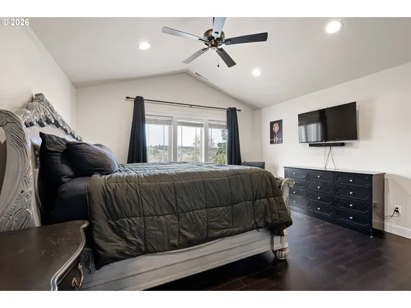 a bedroom with a bed window and a flat screen tv