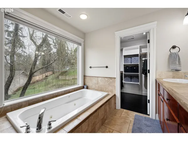 a bathroom with a granite countertop sink and a large window