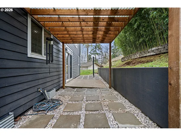a backyard of a house with large trees and outdoor seating