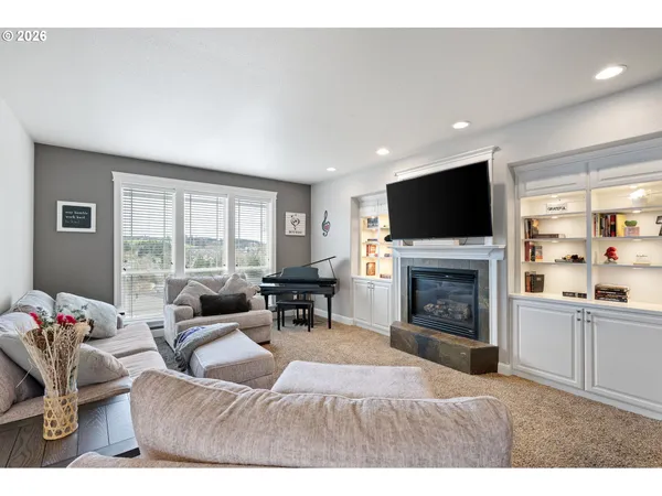 a living room with furniture a fireplace and a flat screen tv