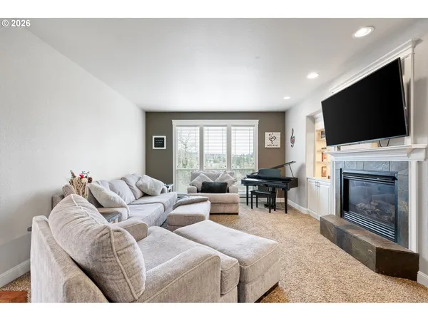 a living room with furniture a fireplace and a flat screen tv