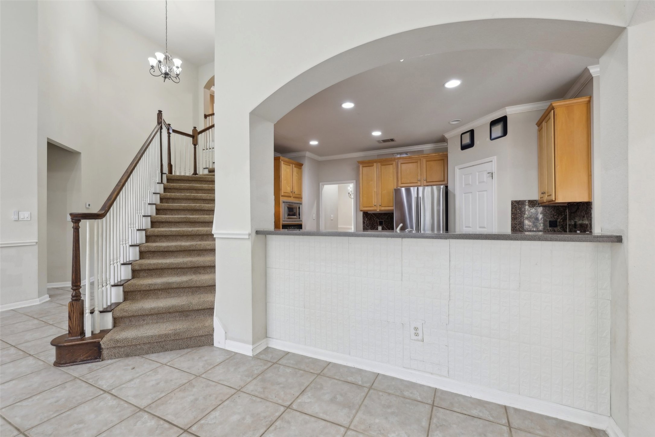 2948 Grimes Ranch Road Austin, TX 78732 - Photo 11 of 40 Unfurnished living room with healthy amount of natural light, a stone fireplace, built in shelves, tile patterned floors, and recessed lighting
