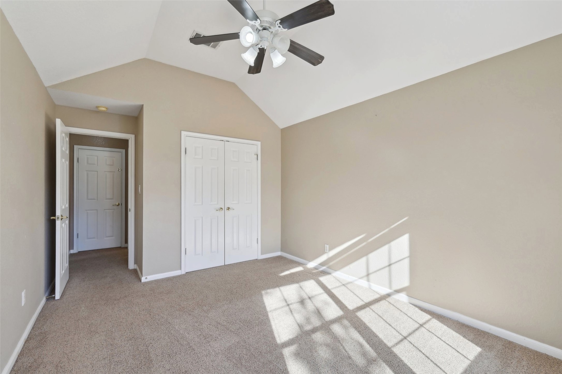 2948 Grimes Ranch Road Austin, TX 78732 - Photo 16 of 40 Carpeted room featuring a vaulted ceiling with a ceiling fan.