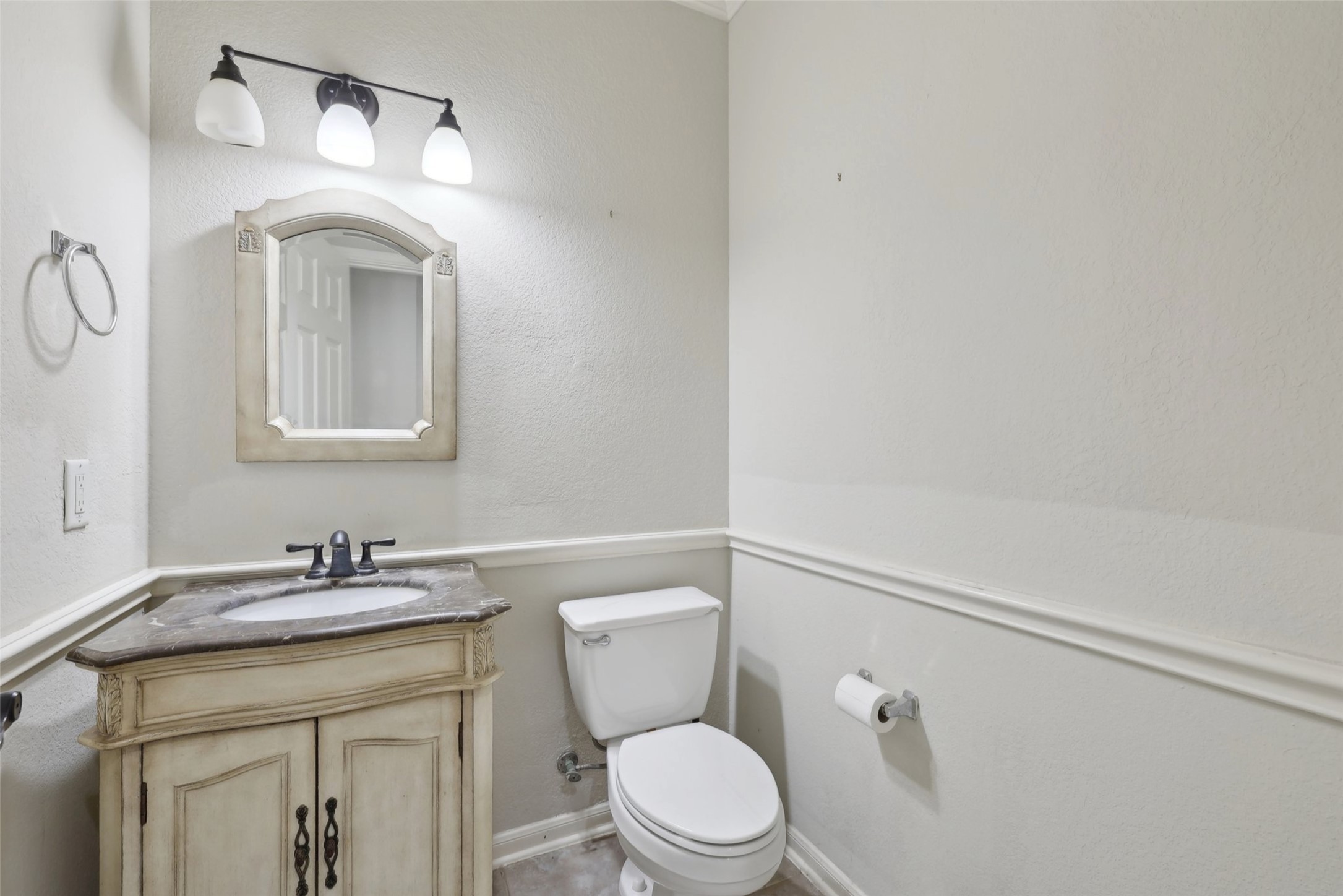 2948 Grimes Ranch Road Austin, TX 78732 - Photo 18 of 40 Bathroom featuring a decorative vanity with a built-in sink, dark countertop, and a matching framed mirror.