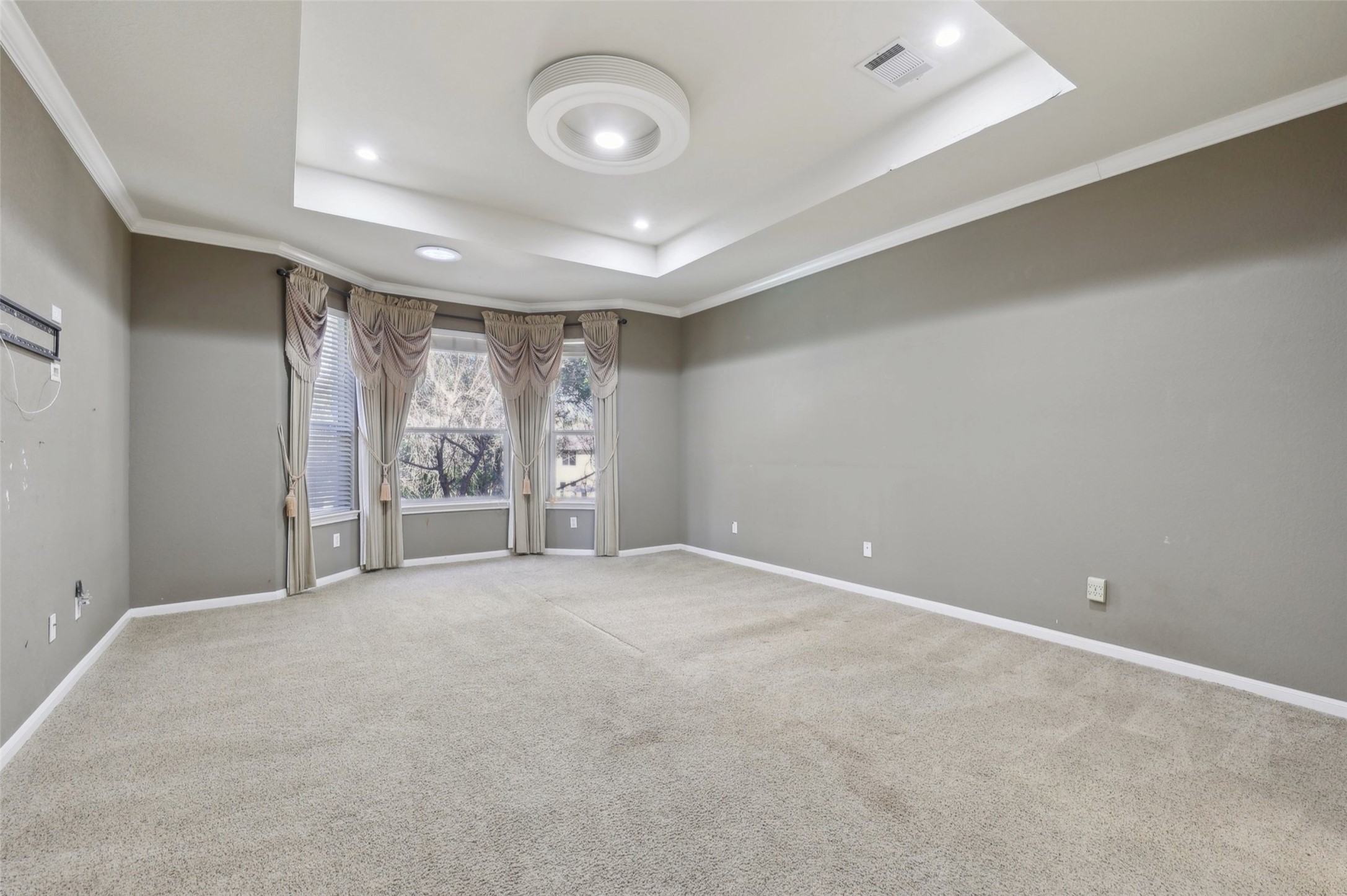 2948 Grimes Ranch Road Austin, TX 78732 - Photo 20 of 40 Spacious room featuring a tray ceiling with recessed lighting and a central flush mount fixture.