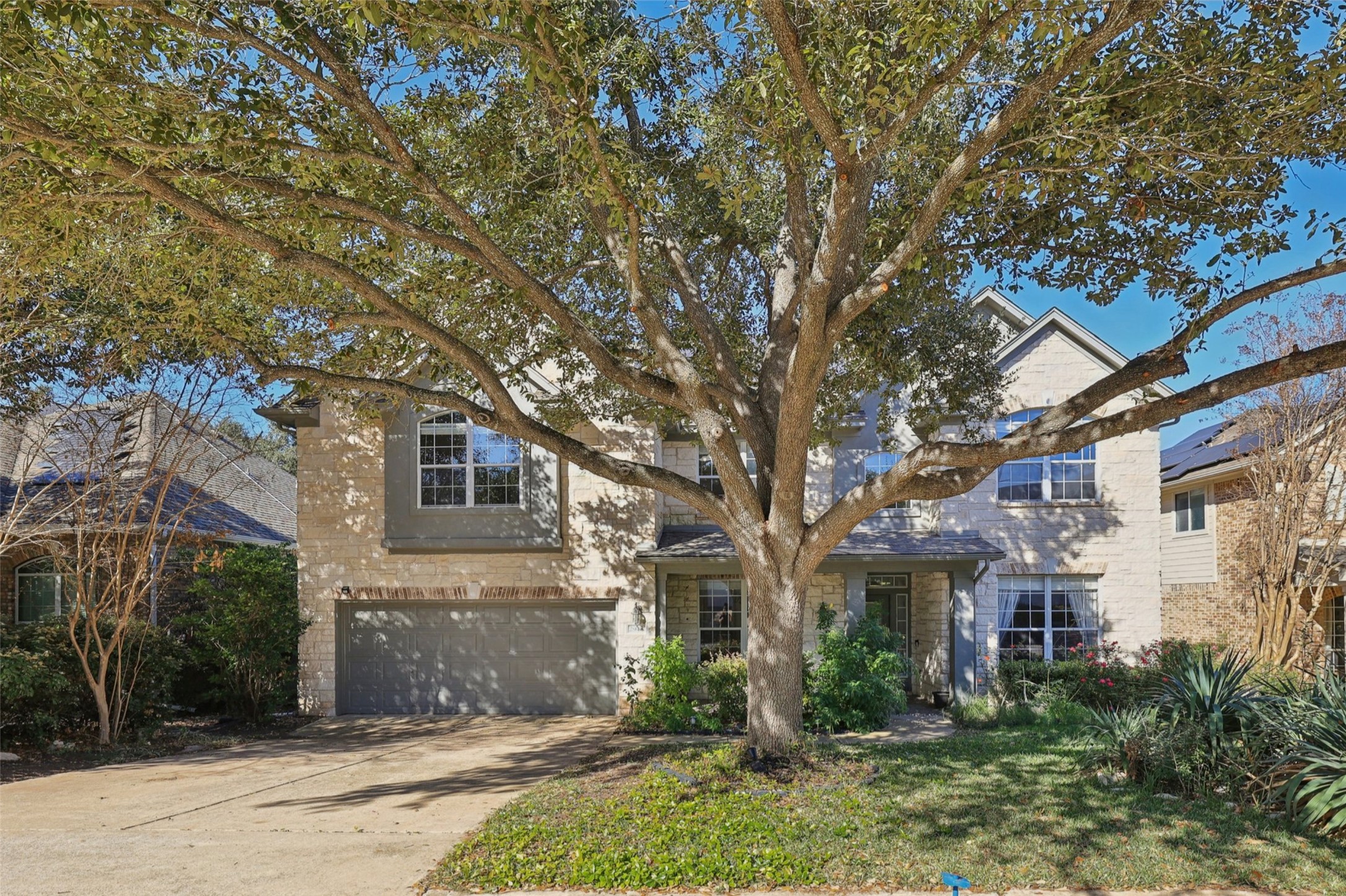 2948 Grimes Ranch Road Austin, TX 78732 - Photo 2 of 40 Traditional-style home with a garage, concrete driveway, and brick siding