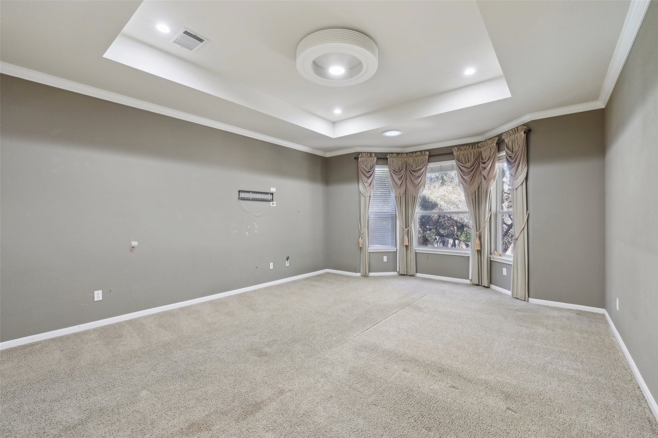 2948 Grimes Ranch Road Austin, TX 78732 - Photo 23 of 40 Spacious room featuring a tray ceiling with recessed lighting and a central flush-mount fixture.