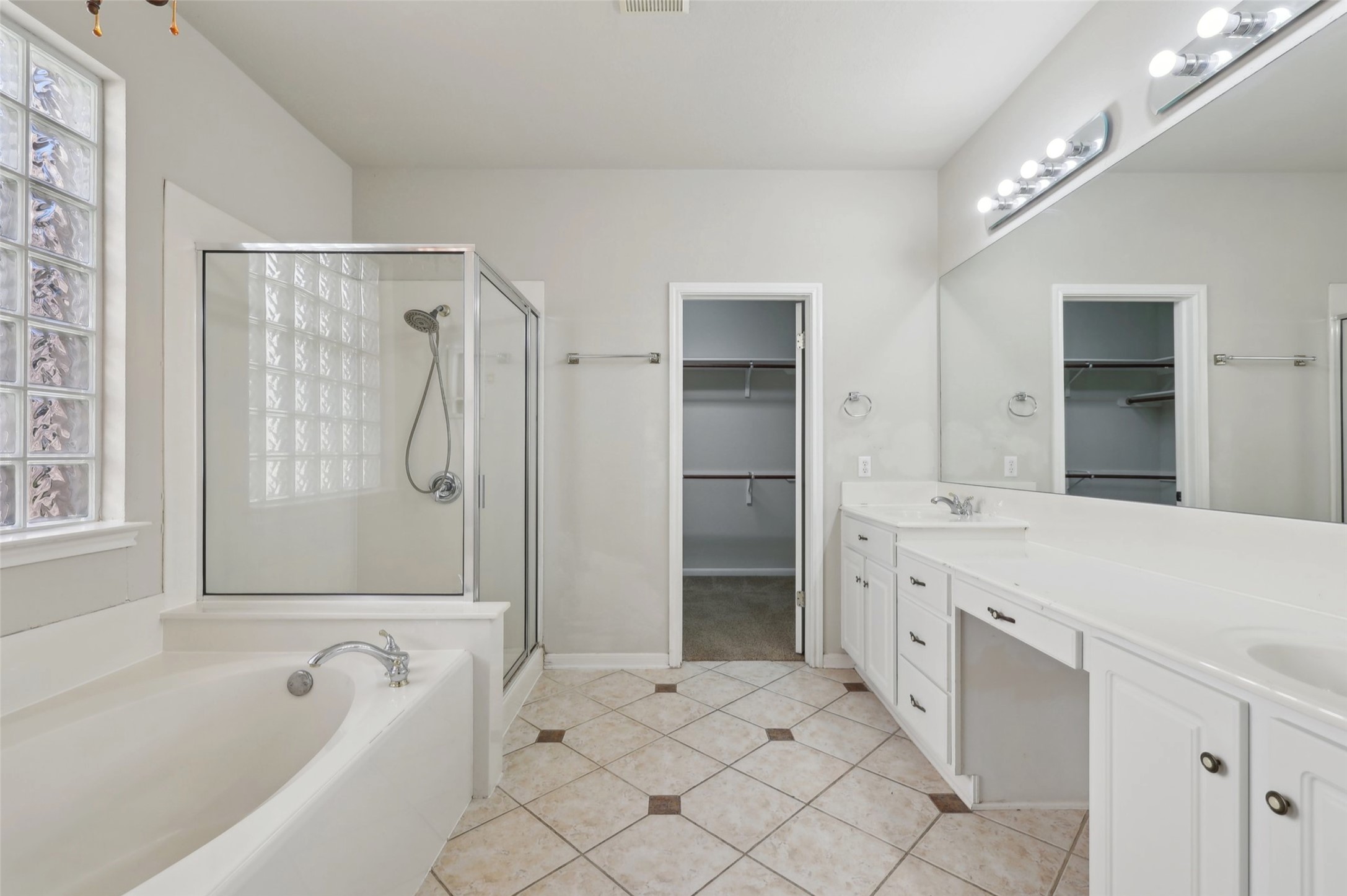 2948 Grimes Ranch Road Austin, TX 78732 - Photo 24 of 40 Full bath featuring a shower stall, double vanity, tile patterned floors, a spacious closet, and baseboards.