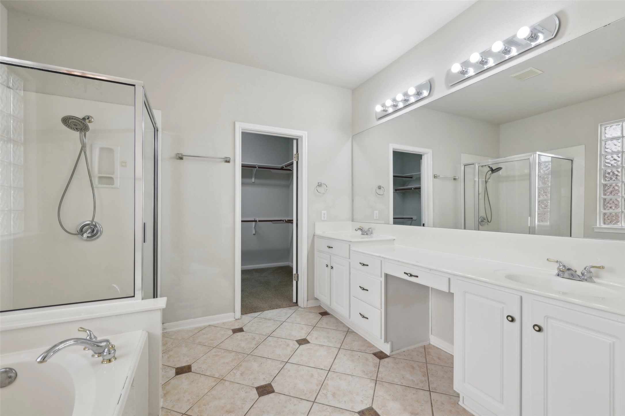 2948 Grimes Ranch Road Austin, TX 78732 - Photo 25 of 40 Full bath featuring a shower stall, double vanity, tile patterned floors, a spacious closet, and baseboards.