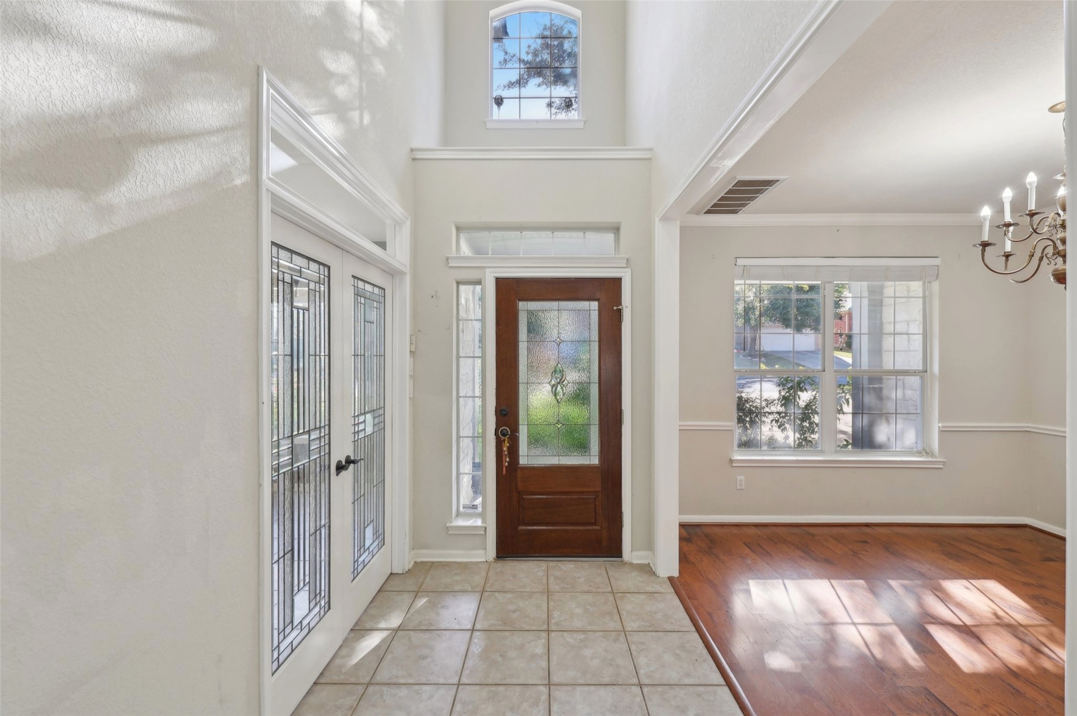 2948 Grimes Ranch Road Austin, TX 78732 - Photo 3 of 40 Foyer with a chandelier, a high ceiling, baseboards, and light wood finished floors