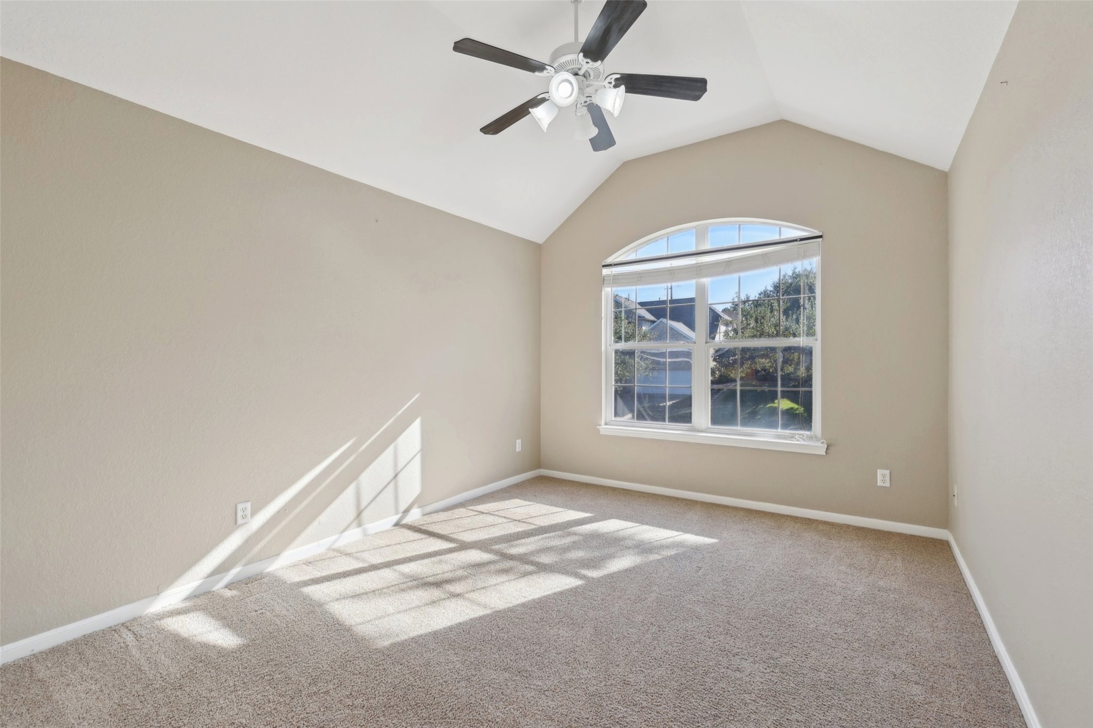 2948 Grimes Ranch Road Austin, TX 78732 - Photo 33 of 40 Room featuring a vaulted ceiling, large arched window, neutral-toned walls, and plush carpeting.