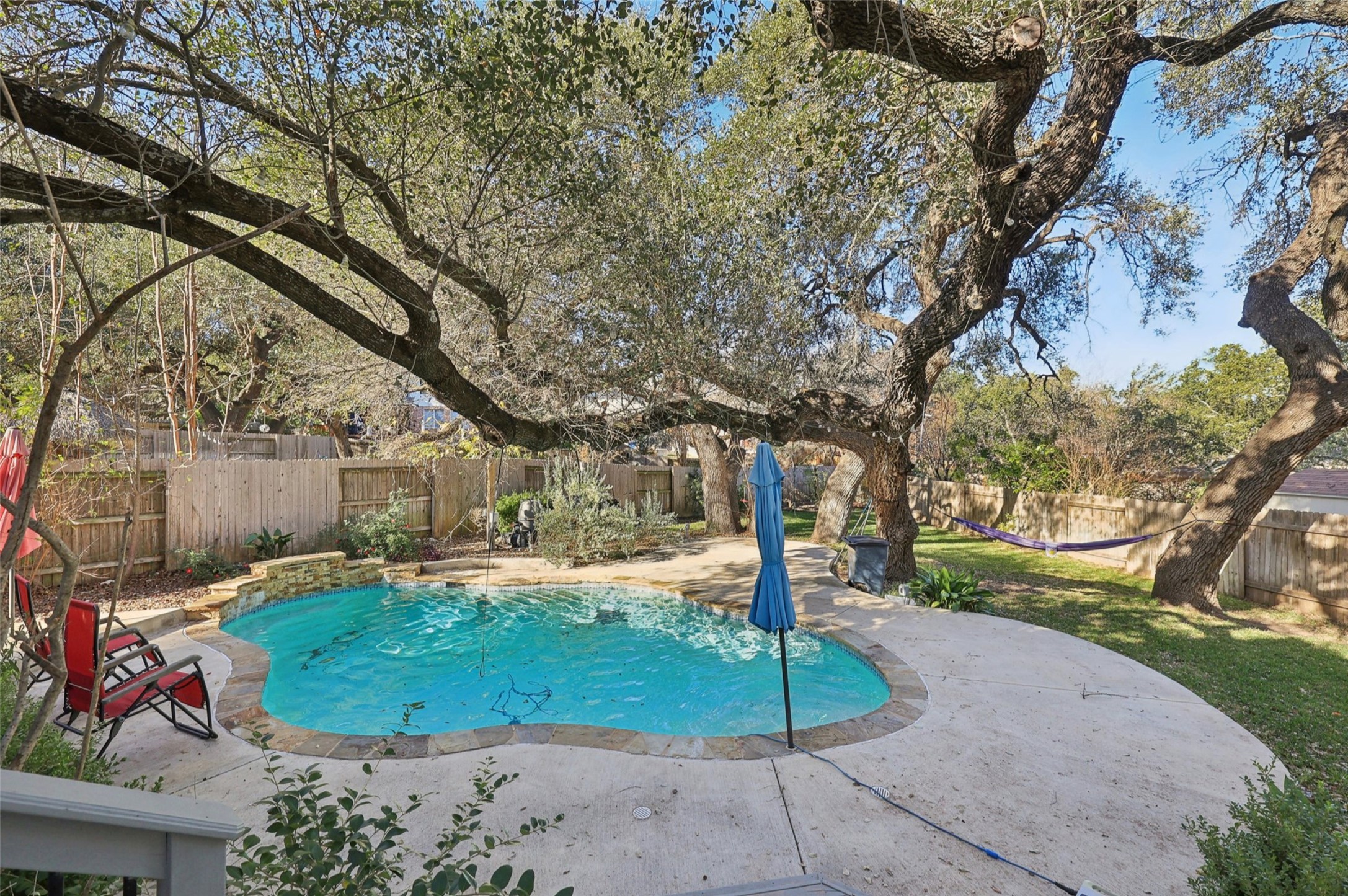 2948 Grimes Ranch Road Austin, TX 78732 - Photo 38 of 40 Outdoor swimming pool with a stone coping, surrounded by a concrete patio.
