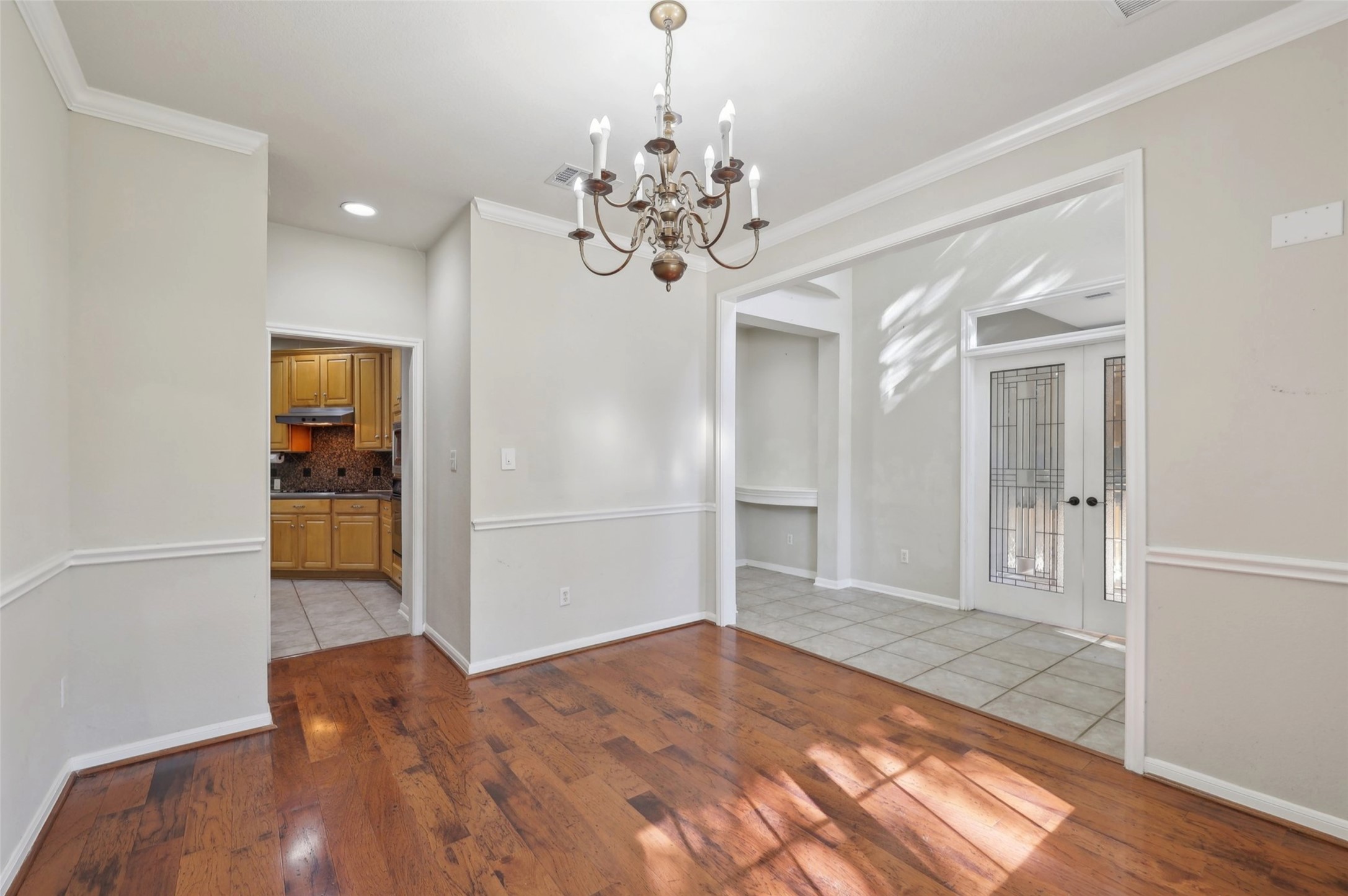 2948 Grimes Ranch Road Austin, TX 78732 - Photo 5 of 40 Unfurnished dining area featuring a chandelier, ornamental molding, wood finished floors, baseboards, and recessed lighting