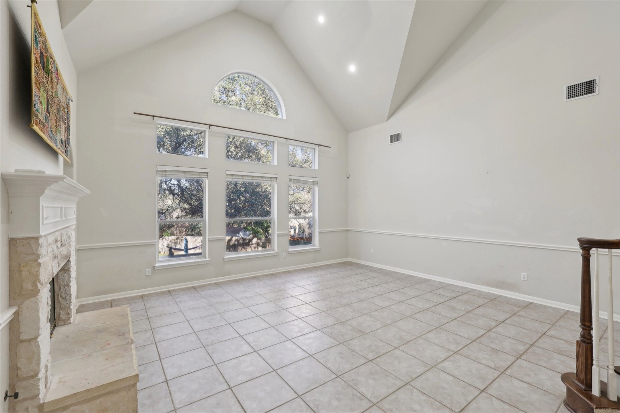 2948 Grimes Ranch Road Austin, TX 78732 - Photo 9 of 40 Unfurnished living room with healthy amount of natural light, a stone fireplace, built in shelves, tile patterned floors, and recessed lighting