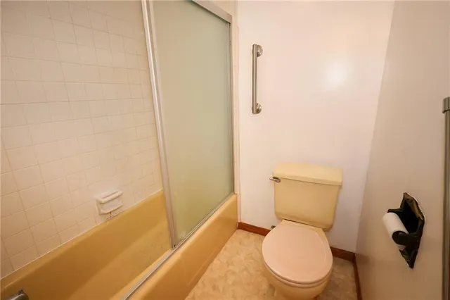 a white toilet sitting next to a shower