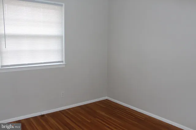 a view of a small space with wooden floor and a window
