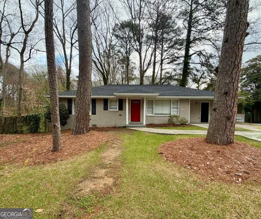 a view of a house with a yard and large tree