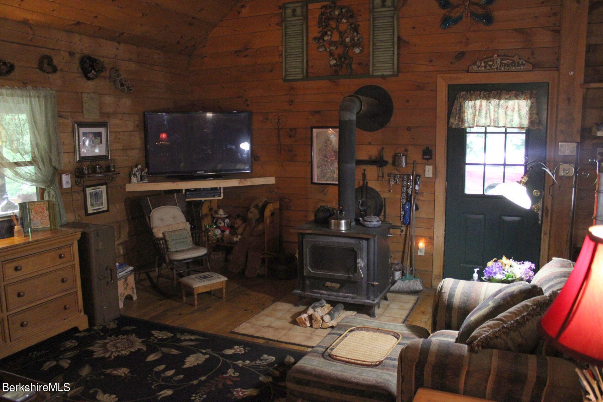 175 River Road Windsor, MA 01270 - Photo 22 of 22 a living room with furniture a flat screen tv and a fireplace