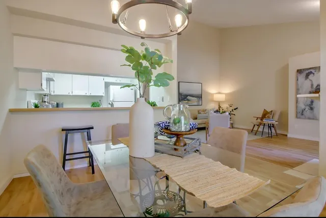 a living room with furniture a chandelier and a dining table