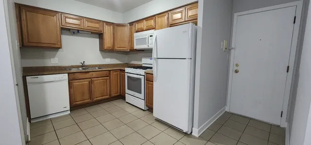 a kitchen with a refrigerator sink and cabinets