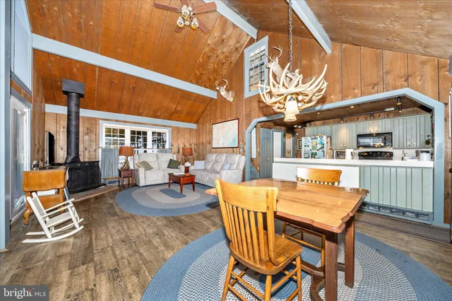 a living room with furniture a large window and wooden floor