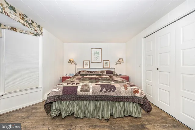 a bedroom with a bed and a large mirror on the dresser