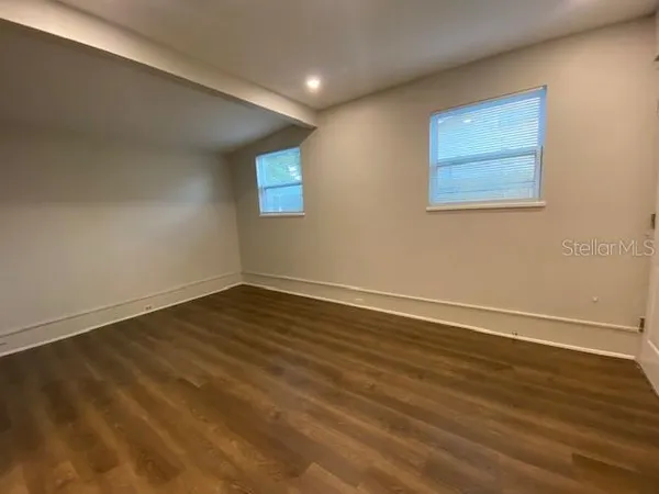 a view of empty room with wooden floor