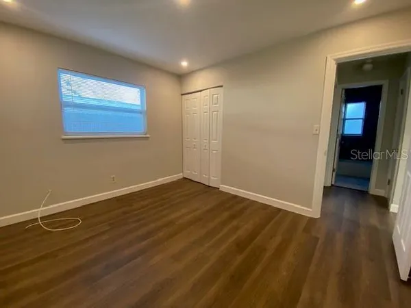 a view of an empty room with wooden floor and a cabinet
