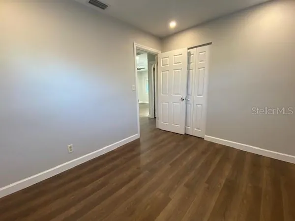 a view of an empty room with wooden floor