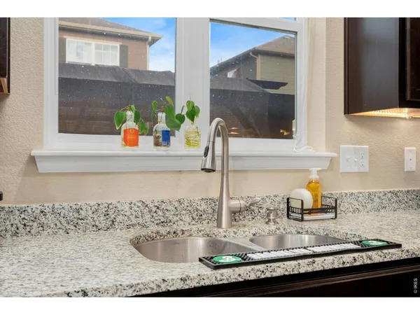 a kitchen with granite countertop a sink and a stove top oven