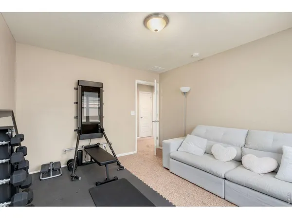 a living room with furniture a rug and white walls
