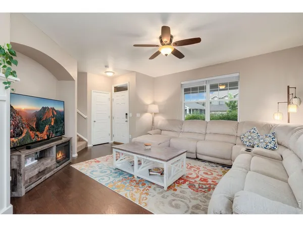 a living room with stainless steel appliances kitchen island a table and chairs in it