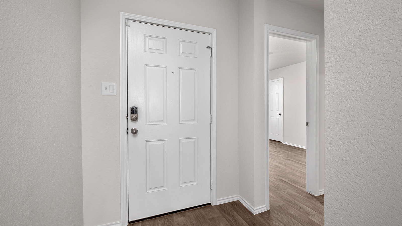 148 McNamara Court Jarrell, TX 76537 - Photo 2 of 22 Foyer entrance featuring a textured wall and dark wood-style flooring
